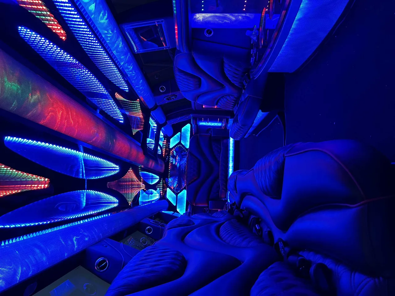 Cadillac Escalade Limousine for party bus rental: seating area, with LED accent lighting and LED ceiling lighting
