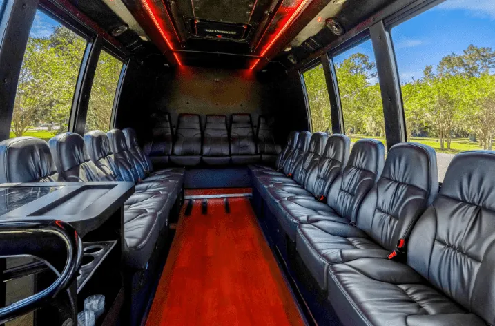 Executive Limousine Bus for party bus rental: seating area, with perimeter lounge seating and LED ceiling lighting
