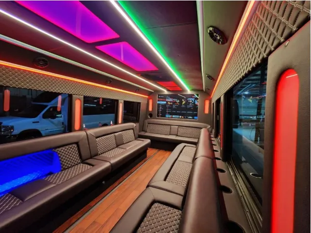 Limousine Bus for party bus rental: seating area, with perimeter lounge seating, LED accent lighting and LED ceiling lighting