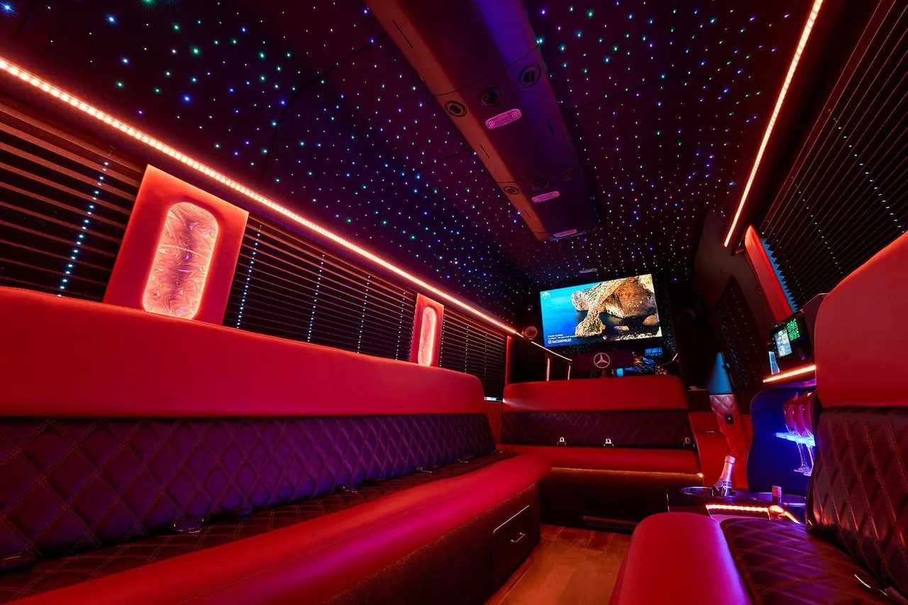 Limousine Bus for party bus rental: seating area, with perimeter lounge seating, window shades and LED accent lighting