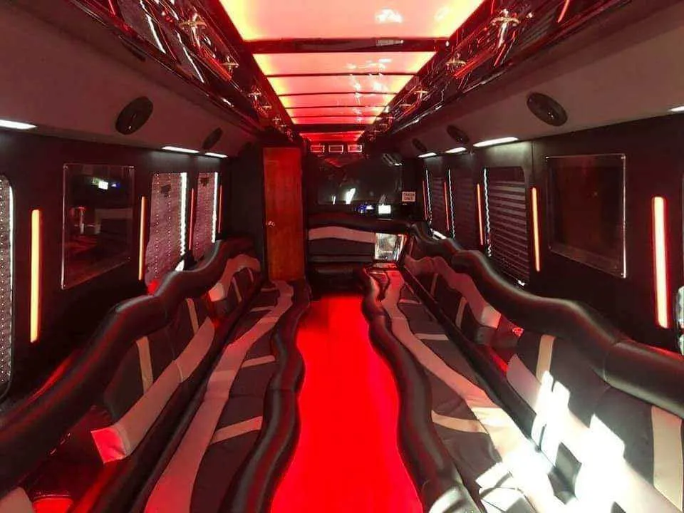 Limousine Bus for party bus rental: seating area, with perimeter lounge seating, LED accent lighting and LED ceiling lighting