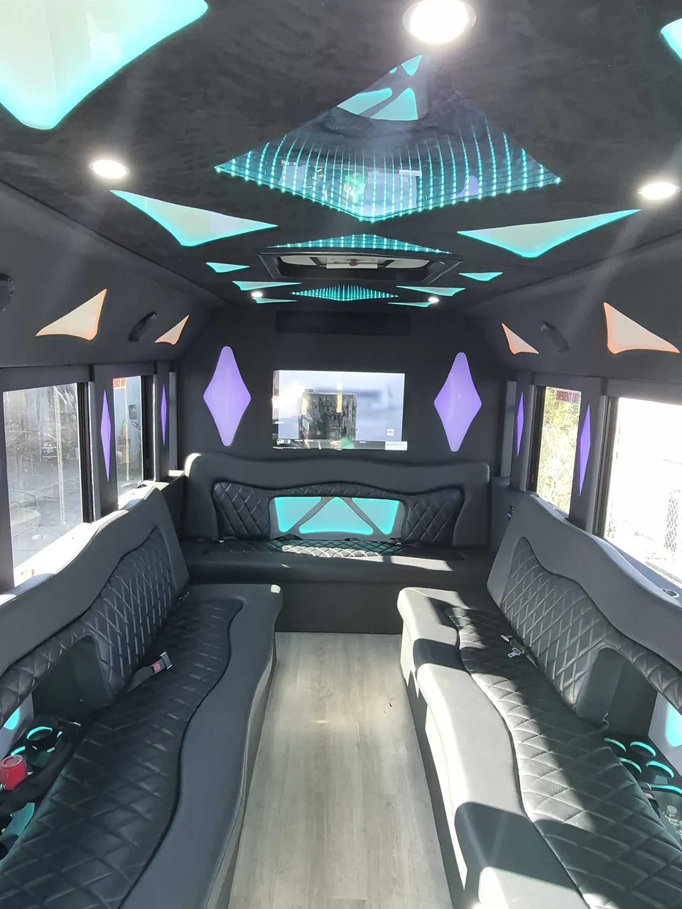 Limousine Bus for party bus rental: seating area, with perimeter lounge seating, LED accent lighting and LED ceiling lighting, pic 6