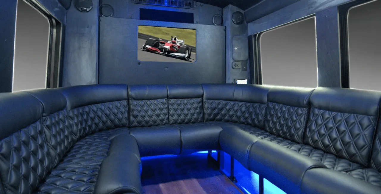 Limousine Coach for party bus rental: seating area, with perimeter lounge seating, sofa-style seating and LED accent lighting
