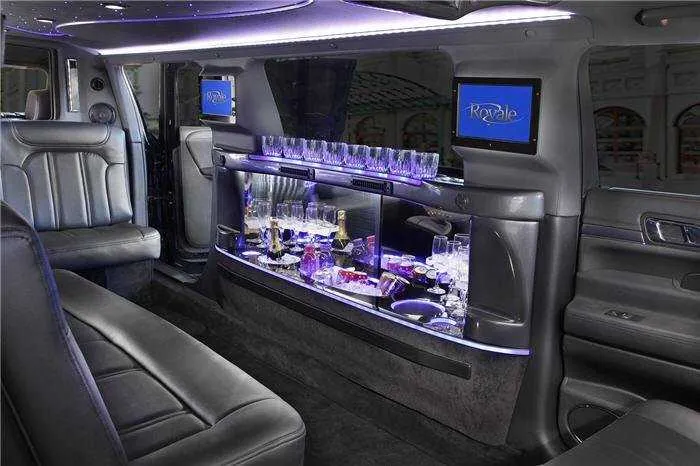 Lincoln MKT Limousine for party bus rental: seating area, with LED accent lighting, bar area and glassware holders