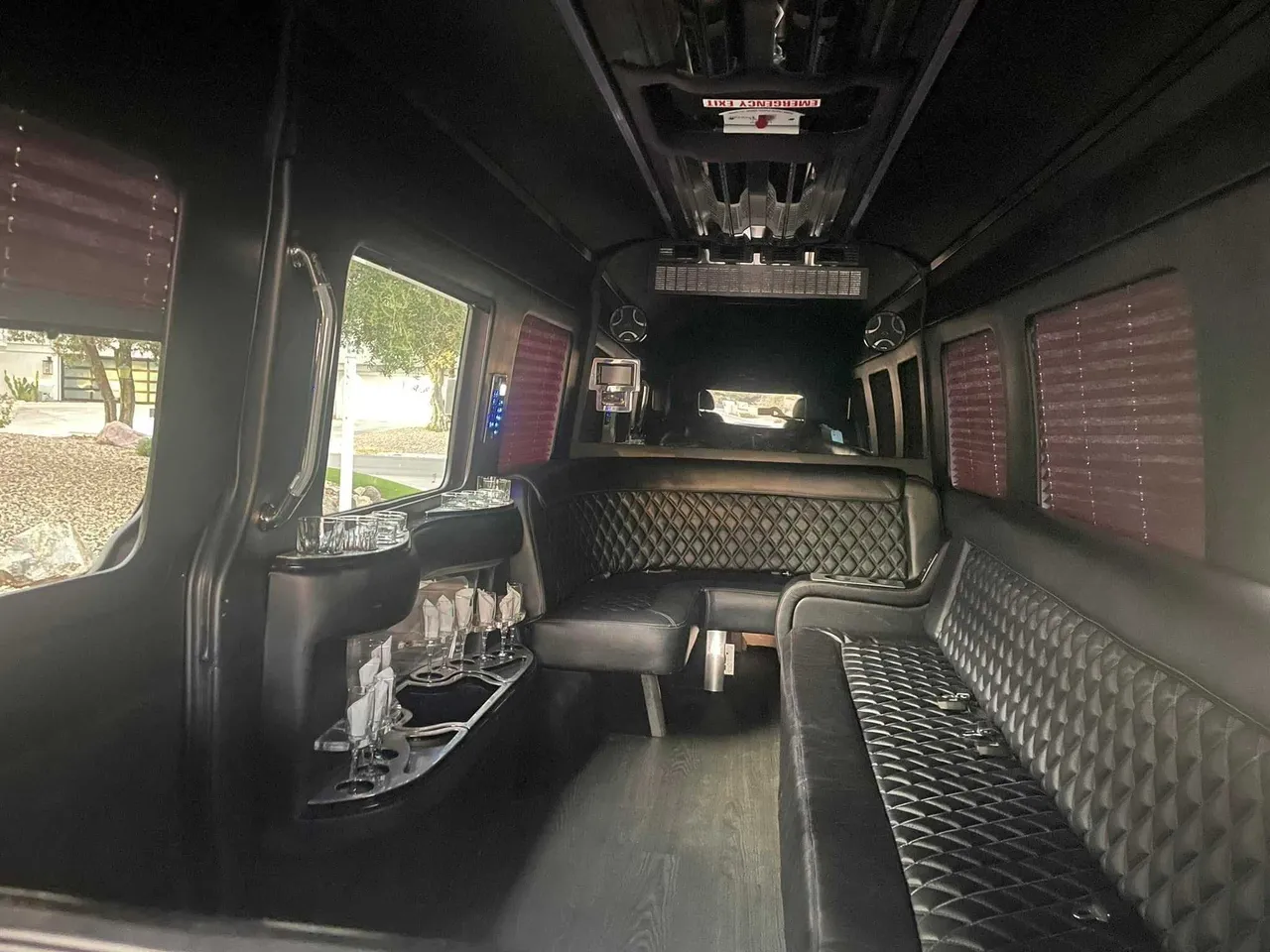 Mercedes-Benz Limousine Sprinter for party bus rental: seating area, with perimeter lounge seating, window shades and bar area