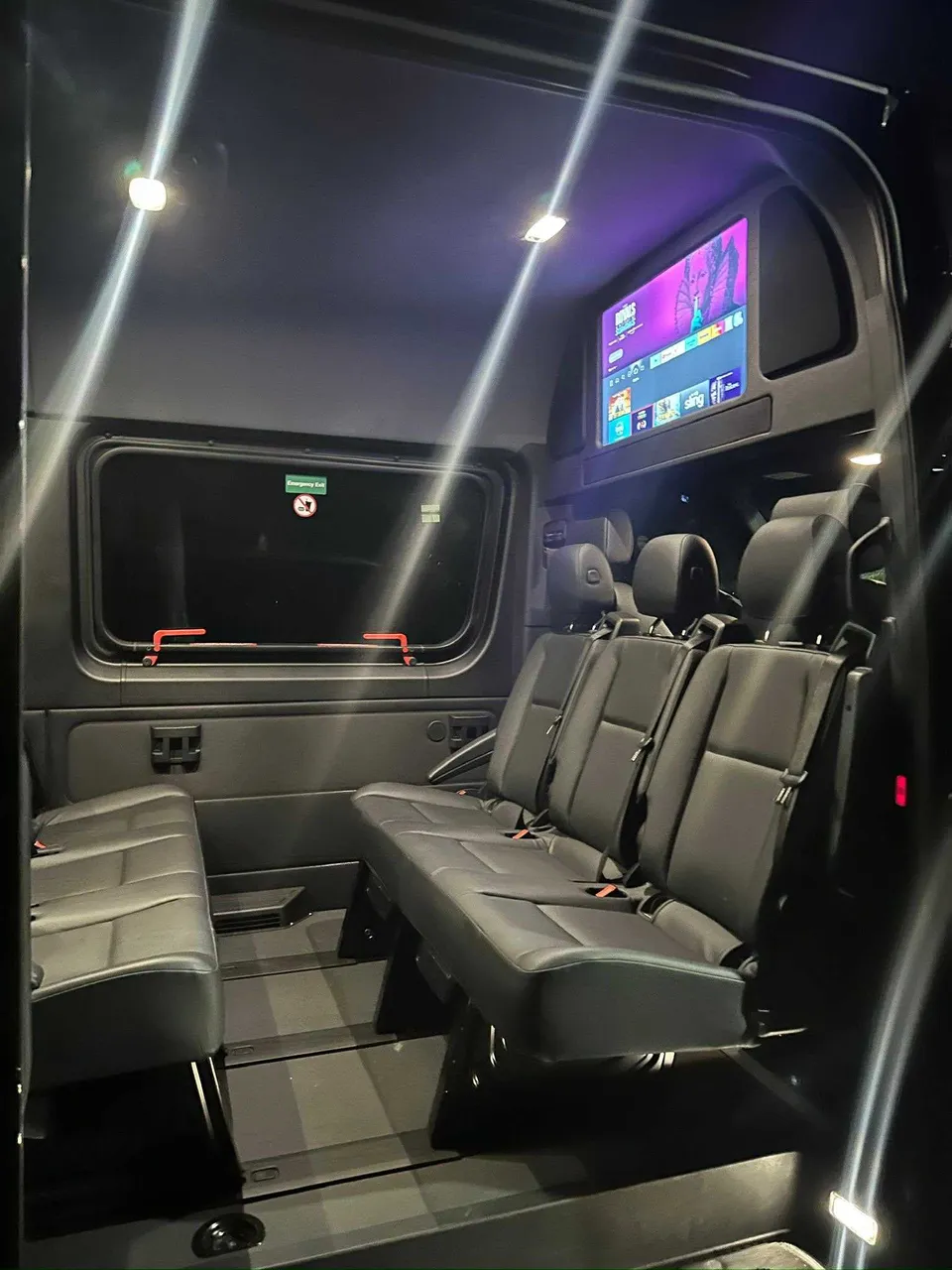 Mercedes-Benz Limousine Sprinter for party bus rental: seating area, with TV screens and passenger seat belts