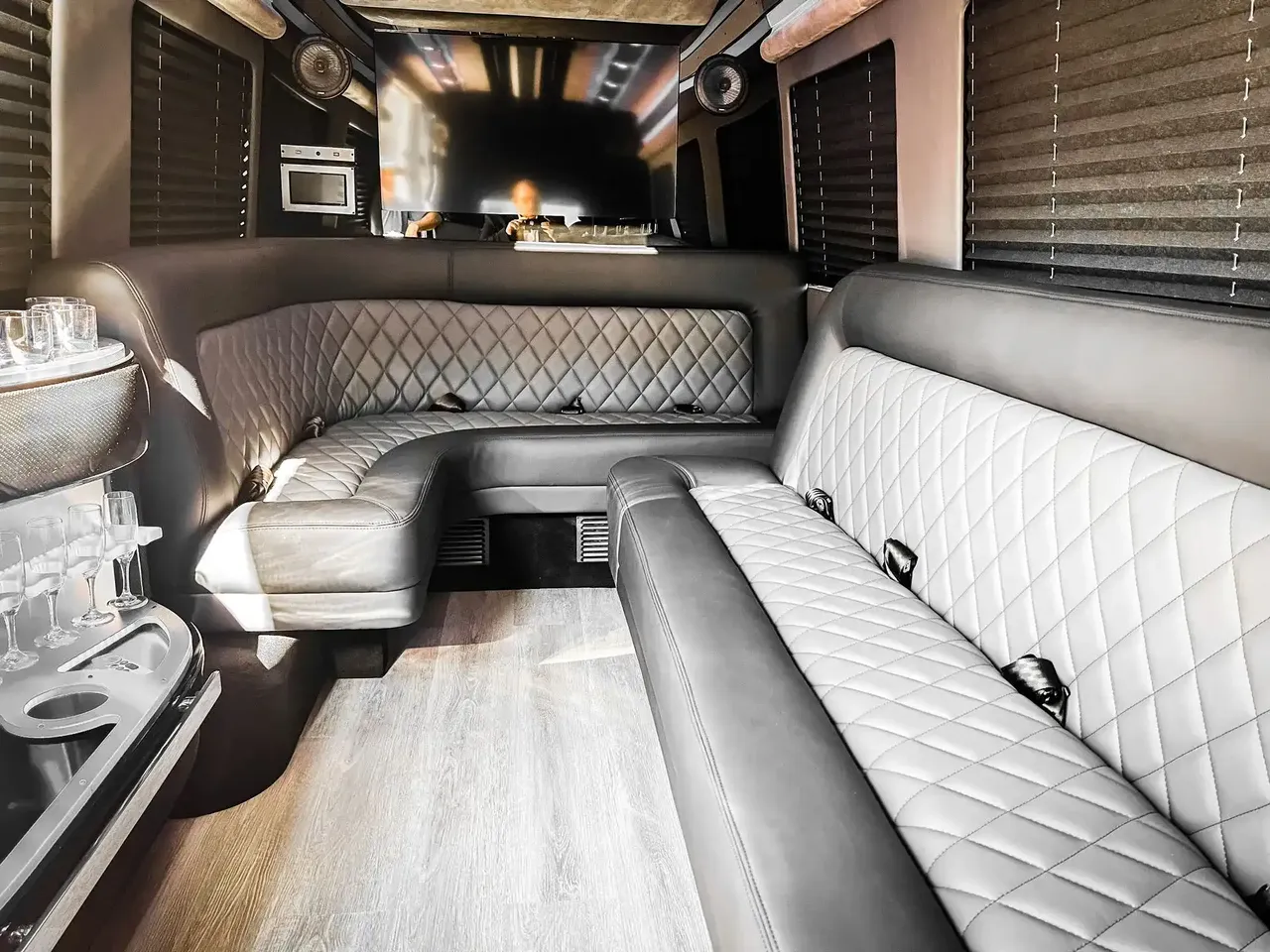 Mercedes-Benz Sprinter Limousine Mercedes-Benz Sprinter Limousine for party bus rental: seating area, with perimeter lounge seating, window shades and wood-look flooring