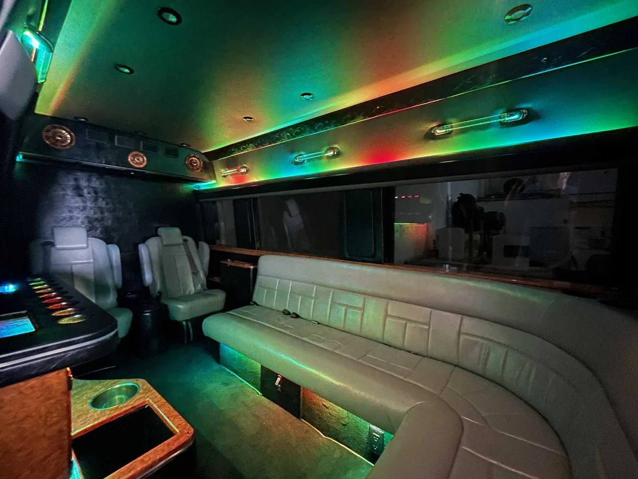 Mercedes-Benz Sprinter Limousine for party bus rental: seating area, with sofa-style seating, captain's chairs and LED accent lighting