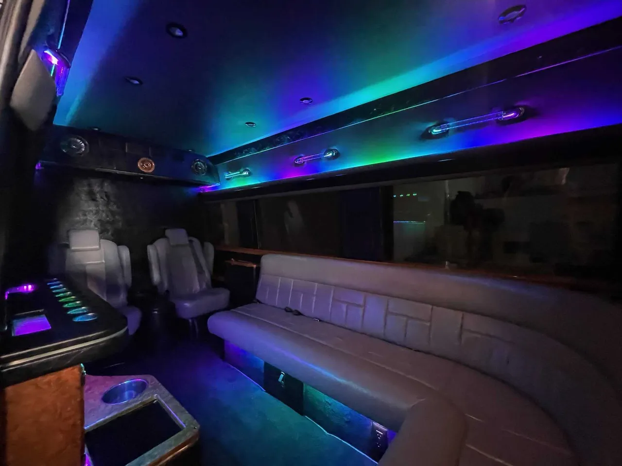Mercedes-Benz Sprinter Limousine for party bus rental: seating area, with sofa-style seating, captain's chairs and LED accent lighting, pic 3