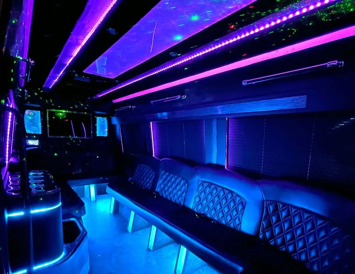 Mercedes-Benz Sprinter XL for party bus rental: seating area, with perimeter lounge seating, window shades and LED accent lighting