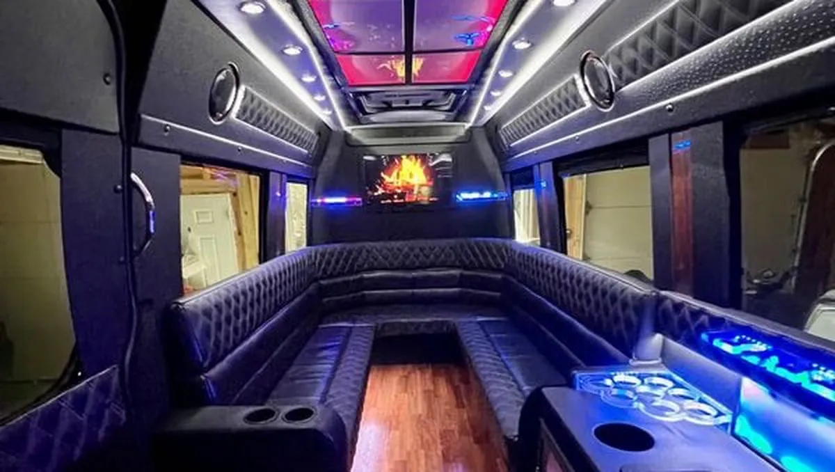 Mercedes-Benz Sprinter XL for party bus rental: seating area, with perimeter lounge seating, sofa-style seating and cup holders
