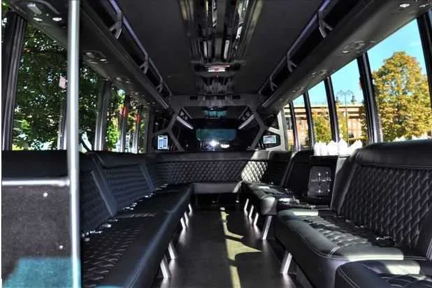 Mini Coach Limousine Bus for party bus rental: seating area, with perimeter lounge seating and dance pole