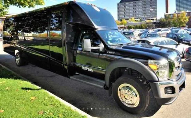 Mini Coach Limousine Bus (black) for party bus rental, with tinted windows
